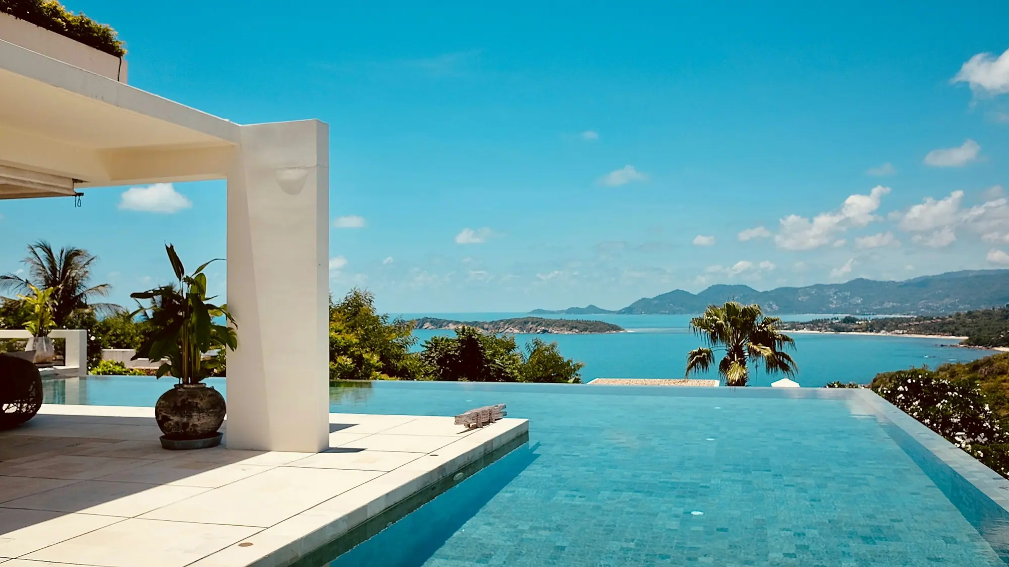 Wit terras met uitzicht over zee en een infinity pool