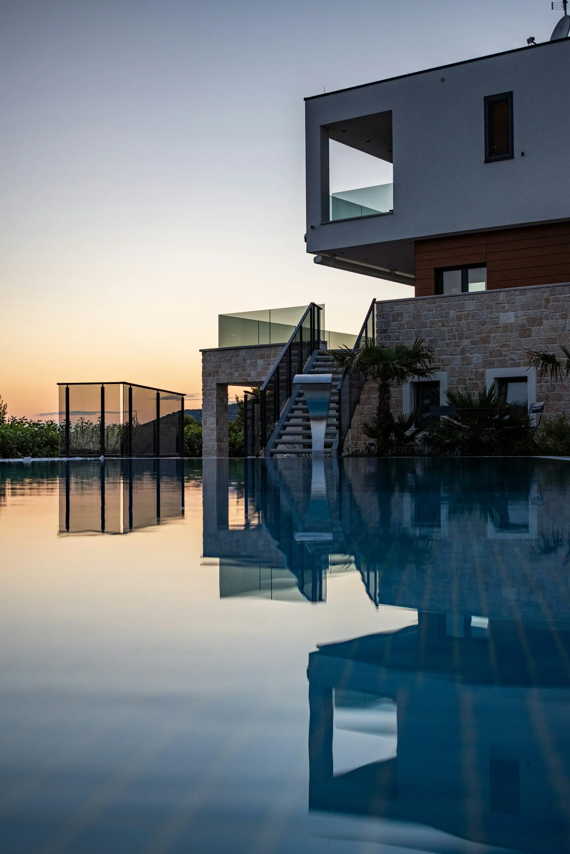 Moderne villa met infinity pool bij zonsondergang